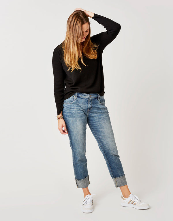 Front view of a women wearing a long-sleeved black shirt and the light blue Carson Jeans, Crave Designs