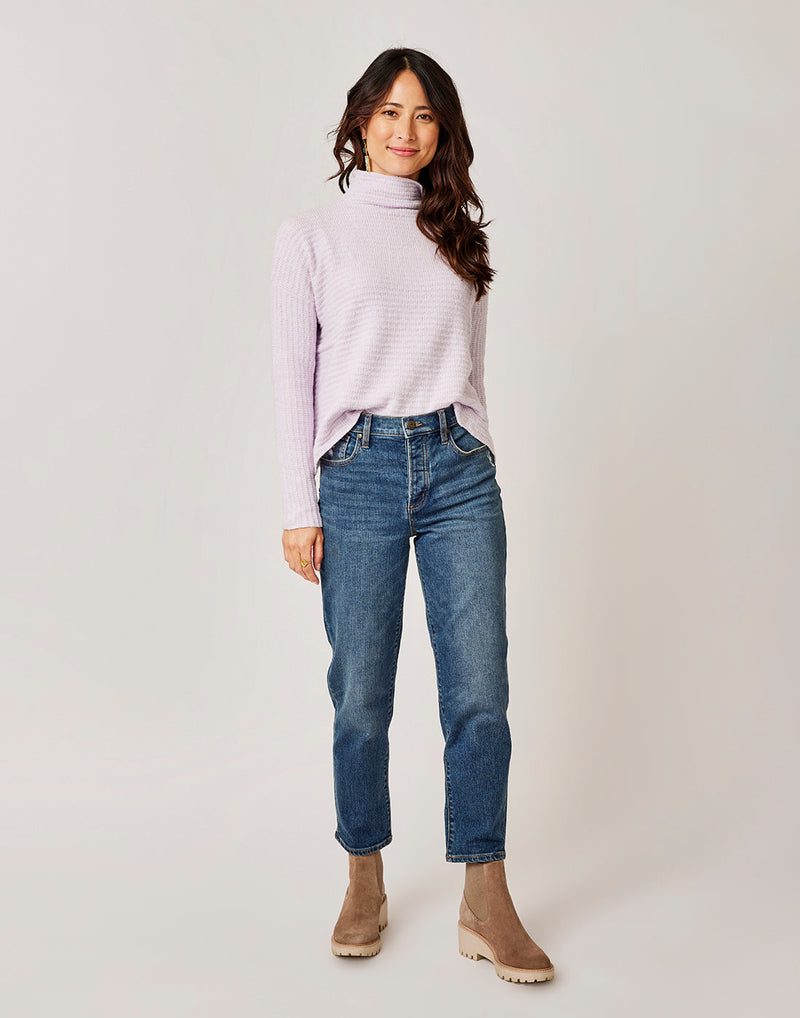 Front view of a woman wearing a white long-sleeved shirt and the blue Brady Straight Leg jeans, Crave Designs