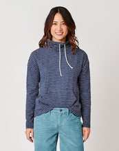 Front view of Woman wearing light blue jean shorts and the navy blue stripe Bodie funnel Neck, Carve Designs